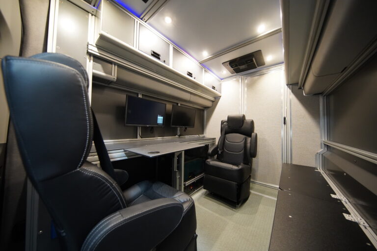 Vandoit unit interior with captain chairs, clinician desk with monitors and overhead cabinets
