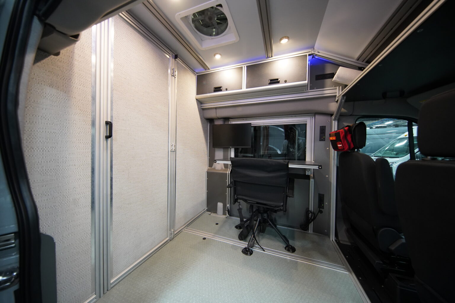 Vandoit unit with a solid partition wall and door, clinician desk and chair visible through the doorway